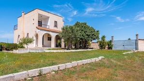 A two-story house with a balcony, a large tree in front, and a blue gate. - Villa Mattalia Relax at Villa for 10, Manduria, Italy (Manduria)