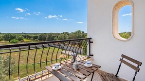A balcony with a view of the countryside, a table with a coffee pot and cups, and a wooden bench. - Villa Mattalia Relax at Villa for 10, Manduria, Italy (Manduria)