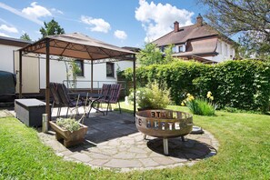 Une terrasse avec des meubles d’extérieur, un foyer et un espace salon abrité.
