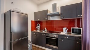 Cozinha moderna com frigorífico, forno, micro-ondas e máquina de café.