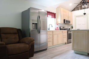 A compact kitchen with a refrigerator, microwave, and sink.