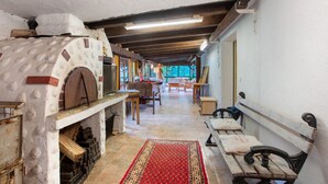 Een rustiek interieur met een houtoven, een lange houten bank en een kamerbreed tapijt.