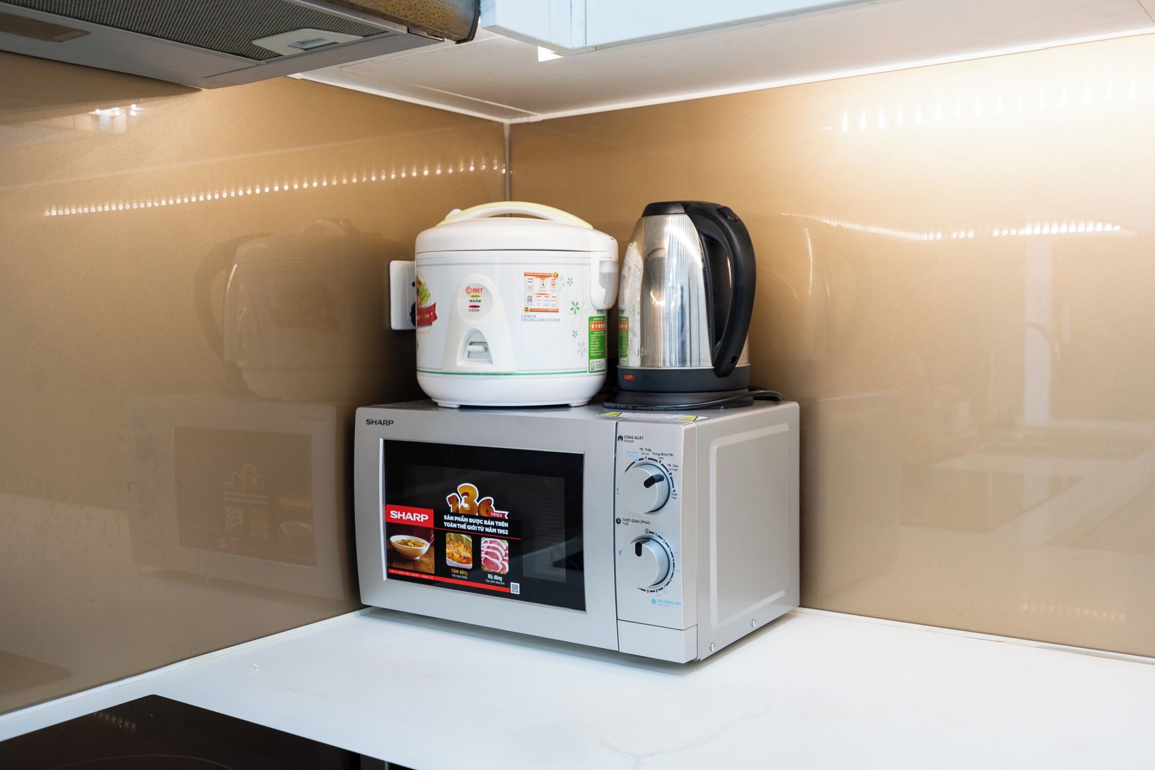 Una cocina compacta con un microondas y una olla de cocción lenta.
