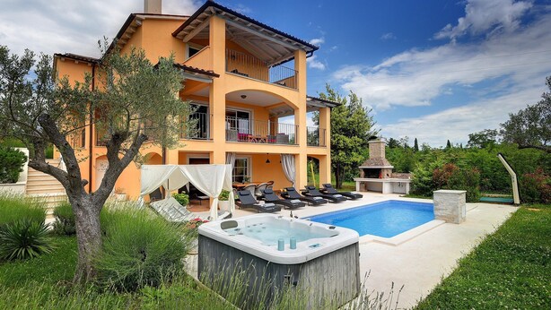 Une maison à deux étages avec une piscine, un espace salon extérieur et un jacuzzi.