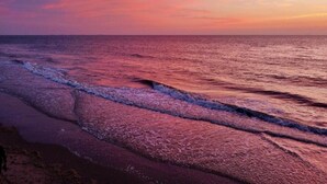 Una spiaggia con onde al tramonto.