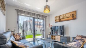 Un salon moderne avec un canapé, une table basse et un téléviseur.