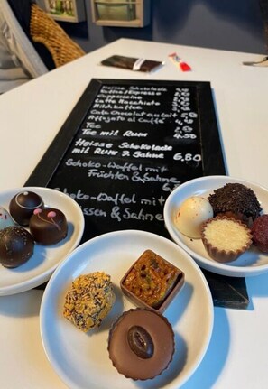 A table with a menu and various desserts. - Meeresbraut Comfortable Holiday Residence (Glowe)
