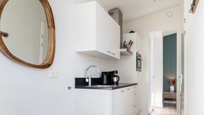 A modern kitchen with white cabinets, a black countertop, and a coffee maker. - Modern Chalet With Beautiful Terrace, in Friesland (Akkrum)