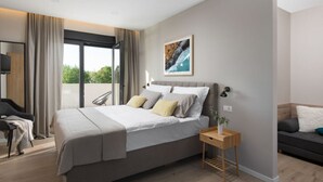 Un dormitorio moderno con una cama grande, una mesita de noche, una silla y vistas al exterior.