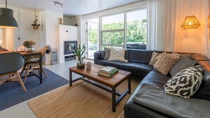 A modern living room with a sofa, coffee table, and a fireplace. - 4 Star Holiday Home in Norre Nebel (Norre Nebel)
