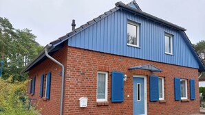 A two-story brick house with blue shutters and a blue roof. - Mari Comfortable Holiday Residence (Koserow)
