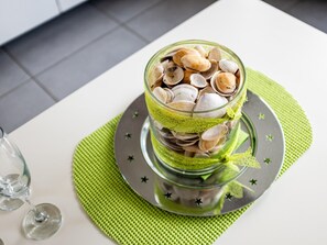A glass bowl filled with clams on a green placemat, placed on a plate with star designs. - Apartment in Koksijde Near the Beach (Koksijde)