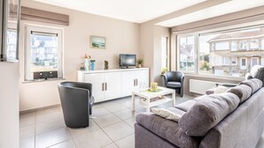 Un salon moderne comprenant un canapé, une table basse, un téléviseur et un meuble.