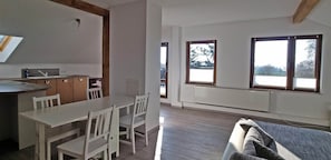 Una cocina moderna con zona de comedor, ventanas amplias y radiador empotrado.