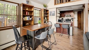 A spacious kitchen with a central island, wooden cabinetry, and a view of the outdoors.