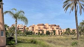 A residential complex with multiple buildings, palm trees, and a well-maintained lawn. - Belvilla by OYO Mar Menor (Torre-Pacheco)