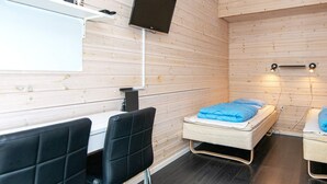 Een moderne kamer met een bed, een bureau en stoelen.