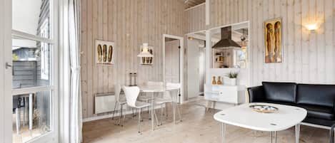 A modern interior with a dining area, a sofa, and a white table.