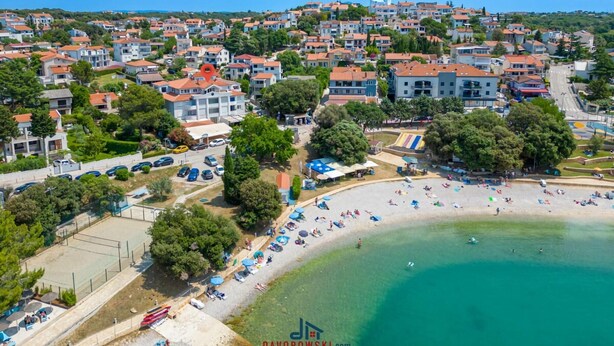 An aerial view of a coastal town with a beach, residential buildings, and a clear sky. - Donatella -apt 2- met Zeezicht (Medulin)