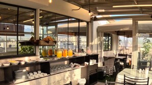 A restaurant with a bar area, outdoor seating, and large windows offering city views. - TERRAMISTICA CENTRO BY CASA CONSUELO   (Arequipa)