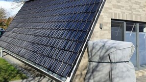 A house with a sloped roof, a solar panel installation, and a garage. - Holiday Home Tim Paul (Butjadingen)