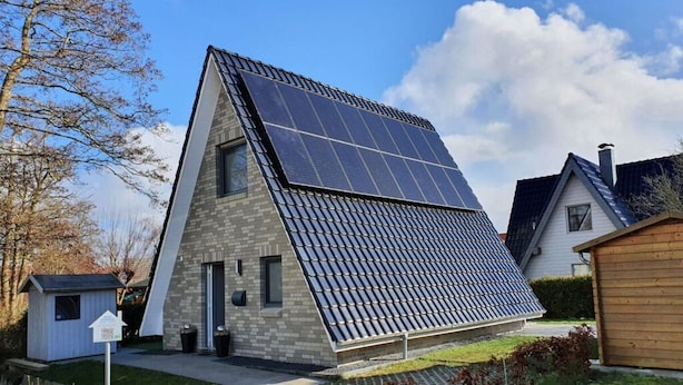 A modern house with a sloped roof, solar panels, and a small shed. - Holiday Home Tim Paul (Butjadingen)