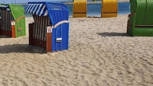 Beach huts numbered 95 and 74, with a sandy beach and the sea in the background. - Holiday Home Tim Paul (Butjadingen)