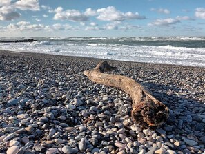A pebbled beach with a large driftwood log in the foreground. - 6 Person Holiday Home in Skagen (Skagen)