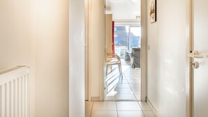 A hallway leading to a living area with a view of the outside. - Apartment in Belgium Near the Sea (Koksijde)