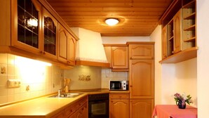 Una cocina con armarios de madera, microondas y lavabo.