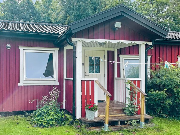A red wooden house with a porch, a window, and a door. - 2 Person Holiday Home in Nodinge (Nodinge-Nol)