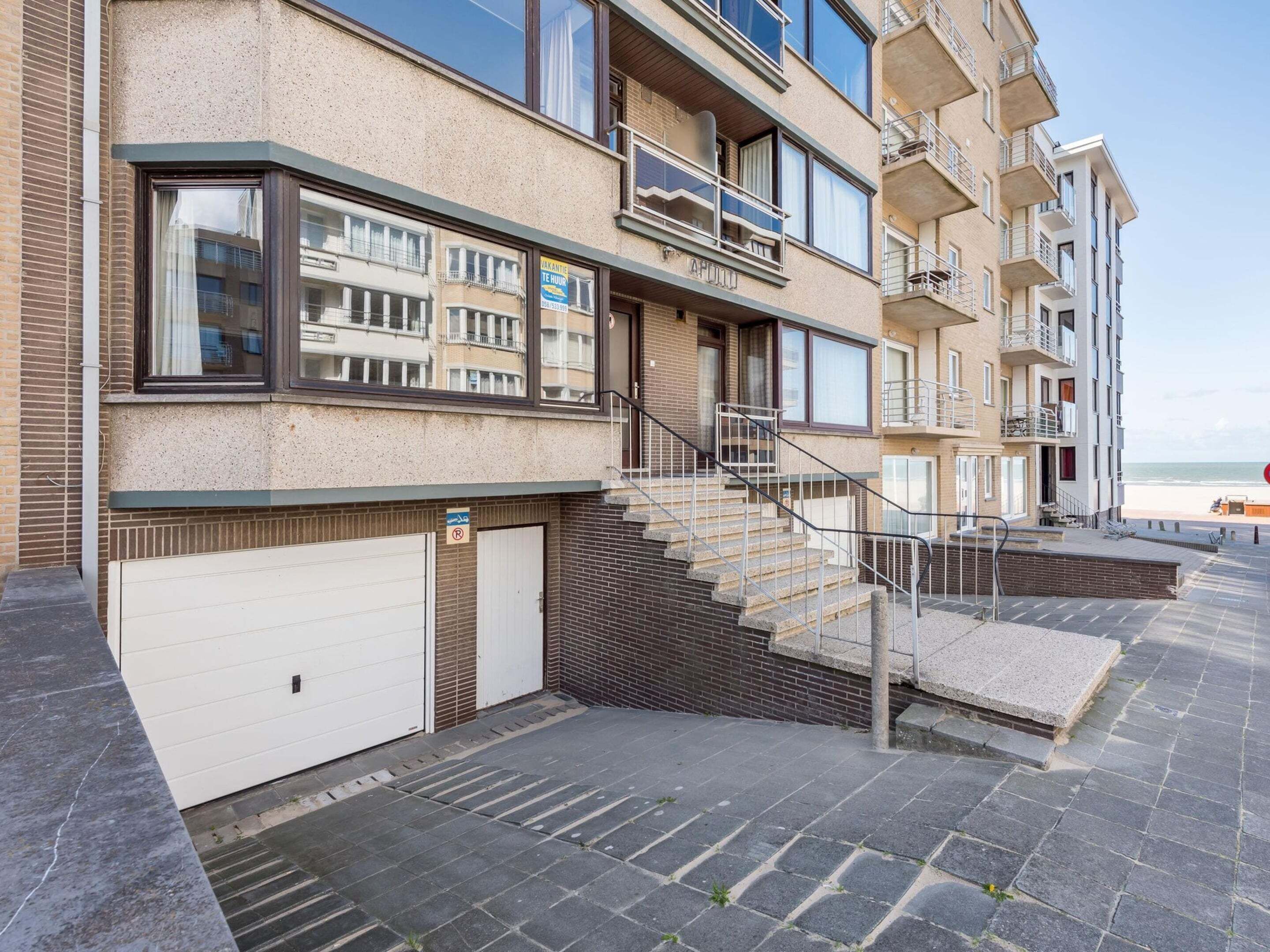 Un immeuble résidentiel à plusieurs étages, avec un escalier menant au rez-de-chaussée.