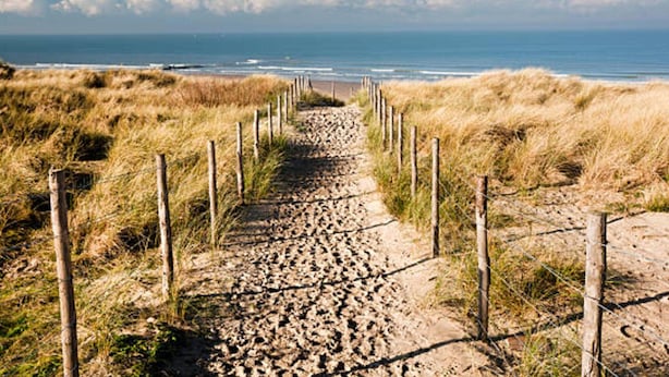 A sandy pathway leading to the beach, flanked by wooden fences and grass. - Charming Home w/ Garden (Ostend)