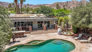 Ein modernes Haus mit Swimmingpool, Terrasse und Bergblick.