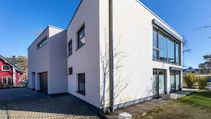 A modern two-story house with a clean, white exterior and large windows. - Holiday Apartment Lore (Breege)
