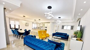 A modern living room with a blue sofa, yellow chairs, and a kitchen in the background. - Apartment in Croatia Near the Adriatic Coast (Malinska-Dubasnica)