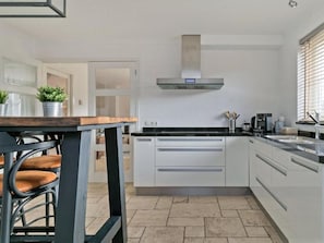 Enjoy cooking in this well-equipped kitchen with a central island, stainless steel appliances, and ample counter space.