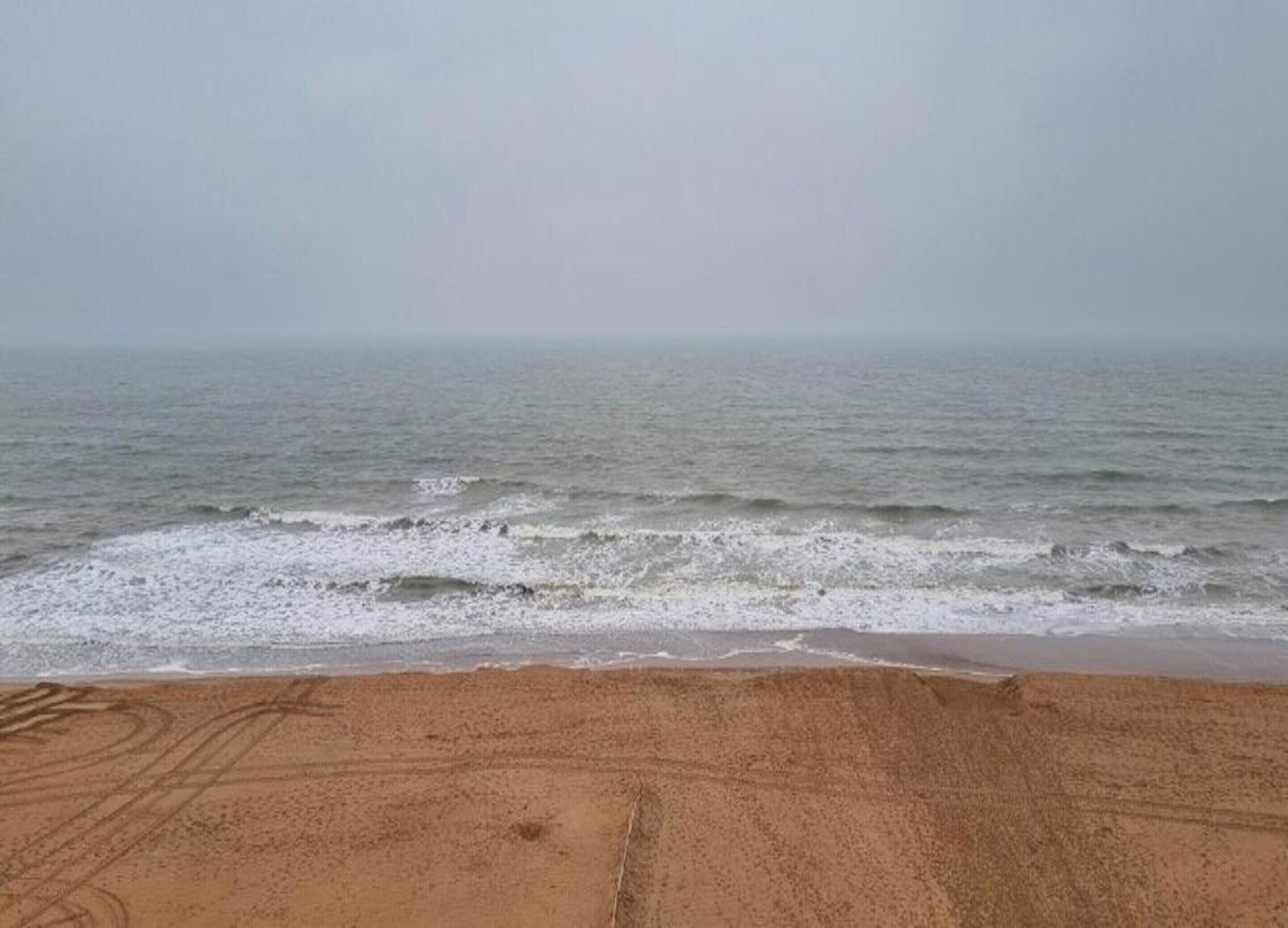 A beach with a sandy shore and the ocean in the background.
