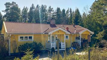 A yellow house with a red-tiled roof, number 39, surrounded by greenery.