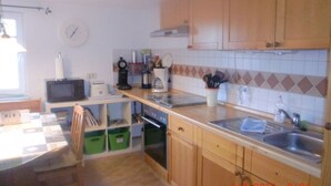 A small kitchen with wooden cabinets, a microwave, a toaster, and a sink.