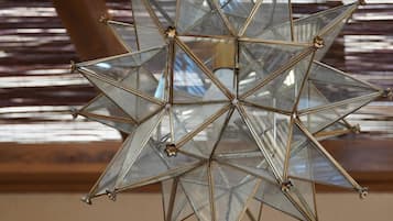 A geometric chandelier with a star-like design, featuring multiple glass panels and metal rods.