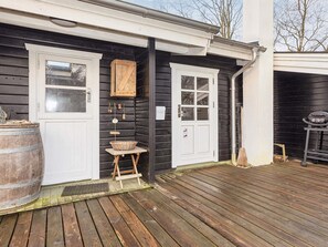 A wooden deck with a rustic mailbox and a small table with a basket. - 5 Person Holiday Home in Veslos (Vesløs)