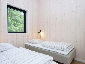 A room with two beds, a window, and a wall-mounted light fixture. - 5 Star Holiday Home in Ebeltoft (Ebeltoft)