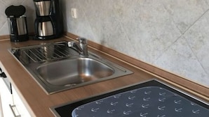 A kitchen with a double sink, a coffee maker, and a toaster. - Holiday Home Steep Coast Fehmarn (Fehmarn)