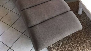 A brown sofa with a cushion and a pillow with an anchor design. - Holiday Home Steep Coast Fehmarn (Fehmarn)