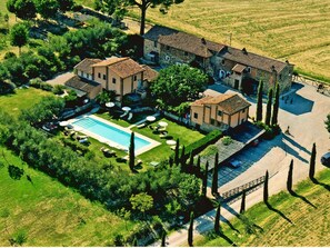 An aerial view of a villa with a swimming pool, surrounded by lush greenery and a stone pathway. - Apartment Near Lake Trasimeno With Pool (Castiglione del Lago)