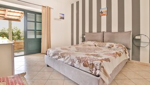 Una camera da letto con un letto, vista esterna e una porta che dà su un balcone.
