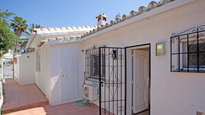 A residential property with a tiled patio, a white door, and a metal gate. - Belvilla by OYO Villa Costabellas (Marbella)