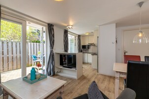 Un apartamento moderno con cocina, comedor y balcón con cerramiento de madera.