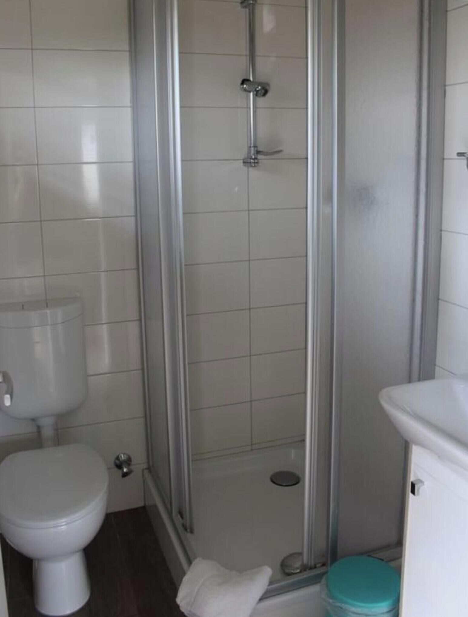 Kylpyhuone, jossa on wc, suihkukaappi ja pesuallas.